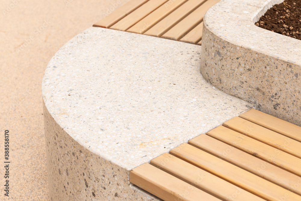 Marble and wooden bench in city park close-up.