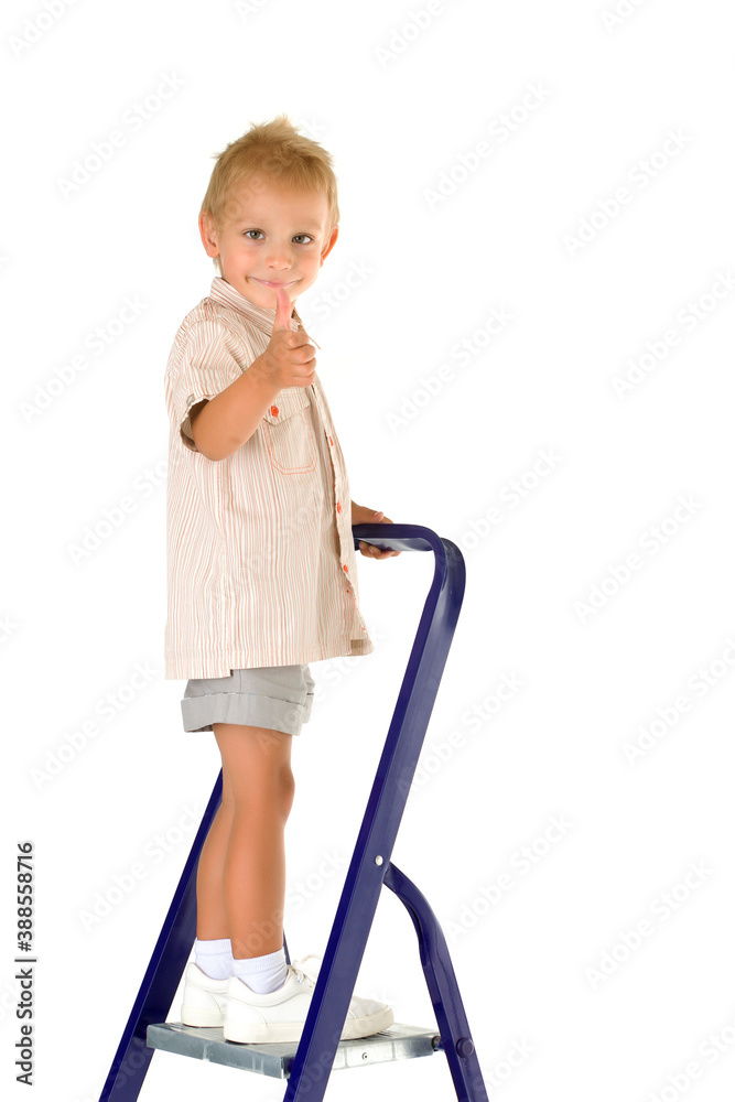 Cheerful little boy climbed a stepladder on the stairs. Cheerful little boy climbed a stepladder on the stairs.