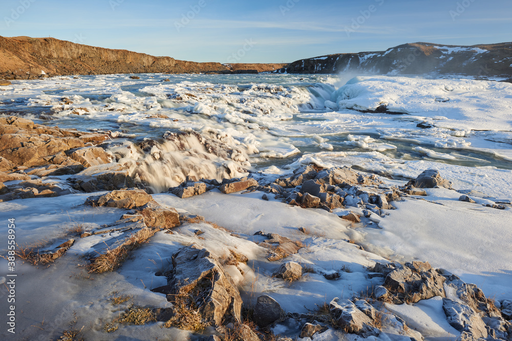 Fototapeta premium Urriðafoss waterfall frozen in winter. Sunrise golden light. South Iceland.