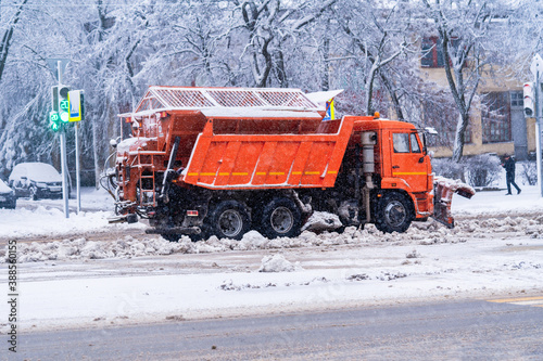 Snowplow clears the road from snow in the city