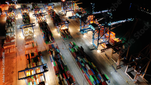 Aerial drone night shot of illuminated container terminal facilities in popular Mediterranean logistics port