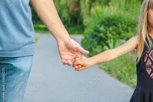 the parent holding the child's hand with a happy background