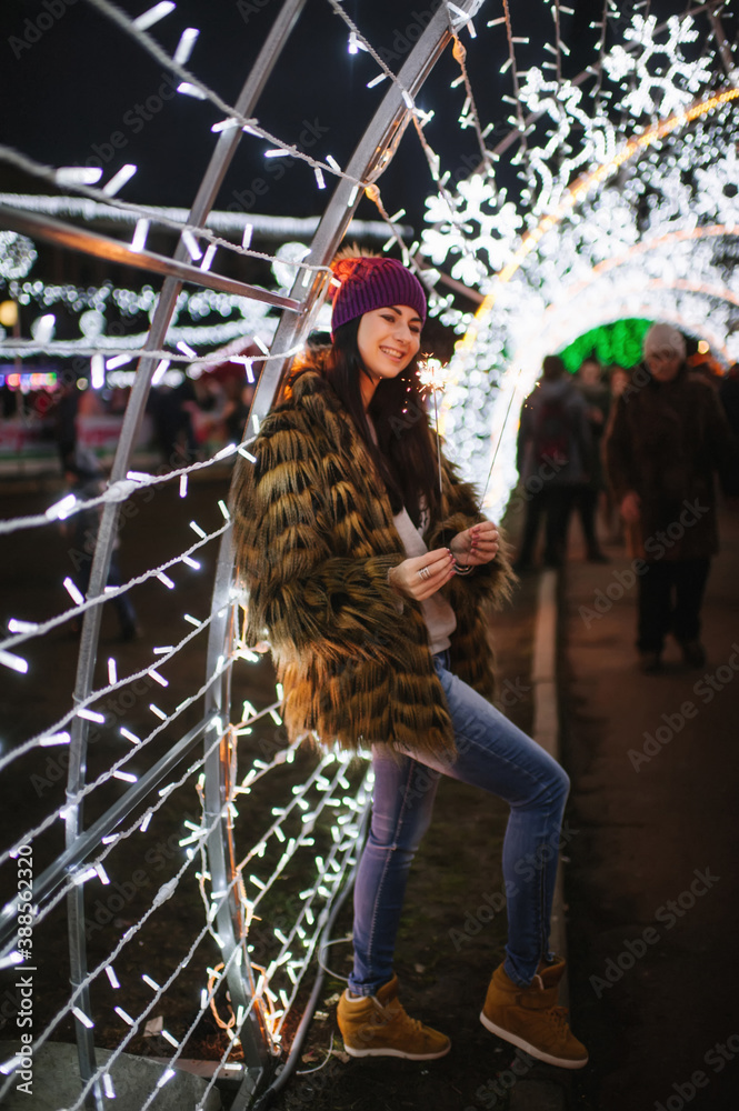 The beautiful young lady standing near Christmas fair 