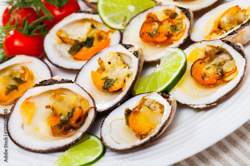 European bittersweet clam appetizers with lime, greens and vegetables