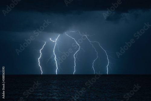 Lightning in the night over the sea photo