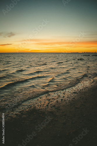 Fototapeta Naklejka Na Ścianę i Meble -  sunrise on the horizon over the brown river water. beautiful colored sky in summer