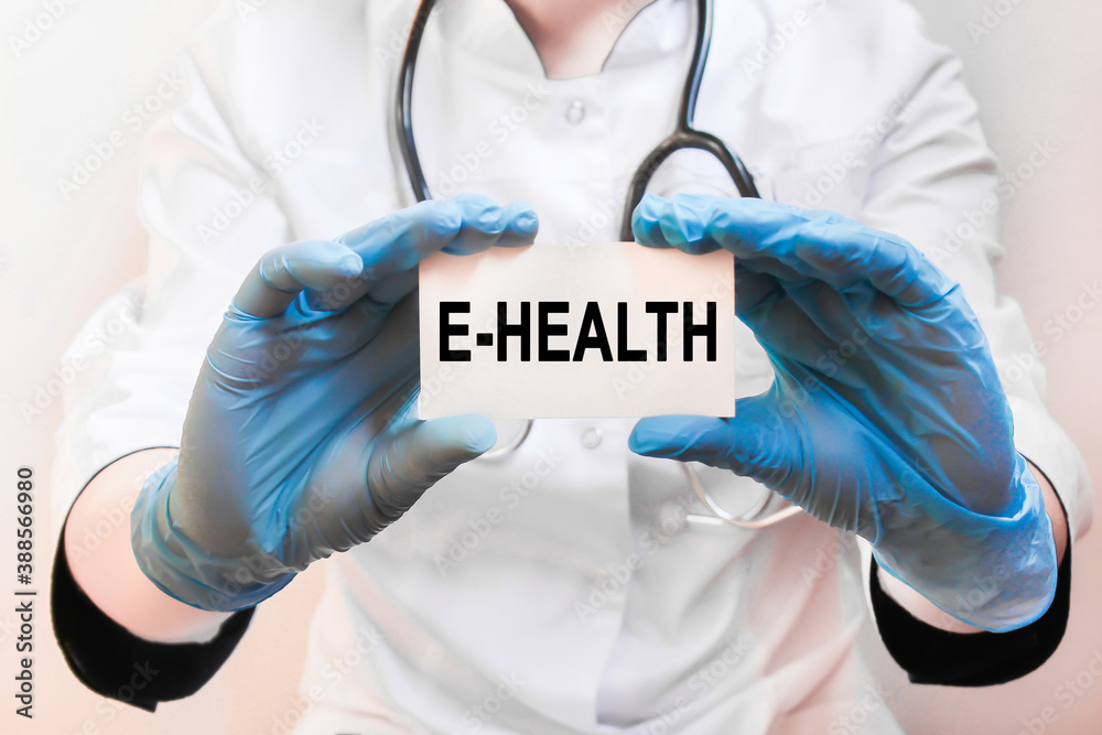 The doctor's blue - gloved hands show the word E-HEALTH - . a gloved hand on a white background. Medical concept. the medicine The doctor's blue - gloved hands show the word E-HEALTH - . a gloved hand on a white background. Medical concept. the medicine