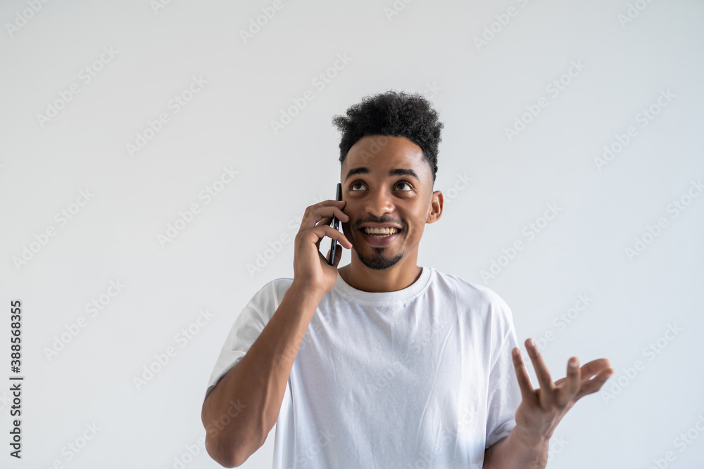 Young smiling african man talking on phone isolated on white background Young smiling african man talking on phone isolated on white background