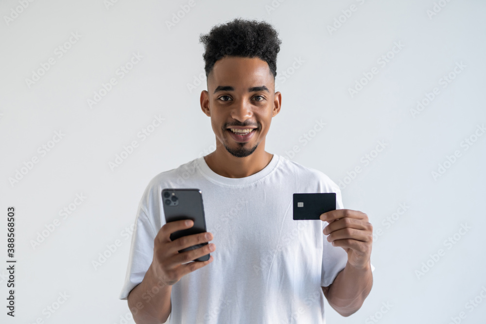 African young man making a payment using his mobile device isolated on white background African young man making a payment using his mobile device isolated on white background