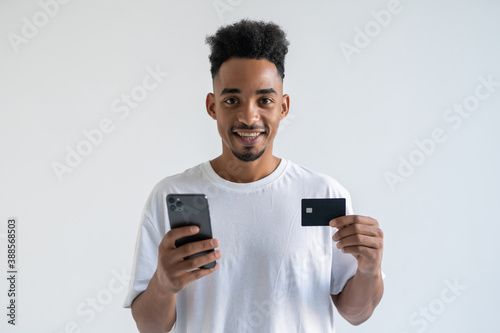 African young man making a payment using his mobile device isolated on white background