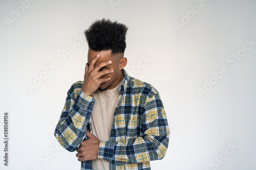 Young african man cover face of shy isolated on white background