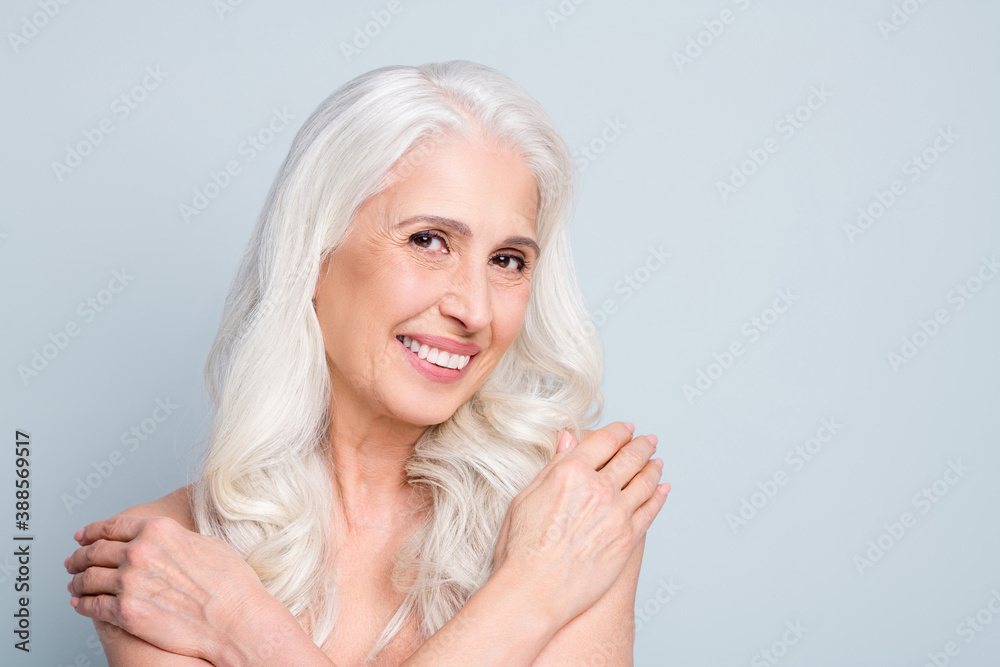Close-up portrait of her she nice attractive cheery grey-haired elderly lady hugging herself copy space isolated on gray pastel color background Close-up portrait of her she nice attractive cheery grey-haired elderly lady hugging herself copy space isolated on gray pastel color background