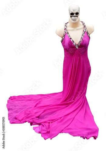 Isolated creepy Halloween decoration mannequin with skull wearing flowing pink dress.
