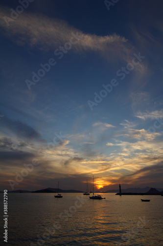 Seascape at sunset. Lighthouse on the coast. Seaside town of Turgutreis and spectacular sunsets