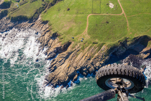 Shore cliffs, waves and wheel. Tandem motor paragliding over Black Sea shores near town of Ahtopol. Sunny autumn day, scenery colors and amazing landscapes and seascapes, Bulgaria photo