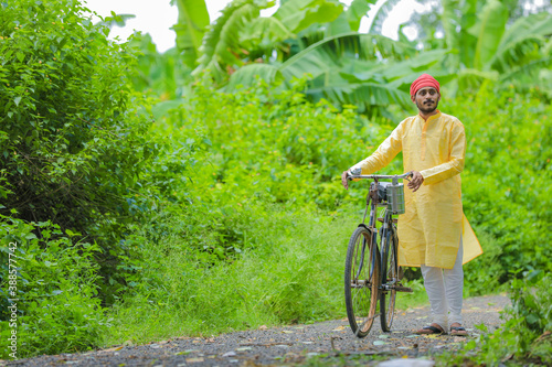Young indian farmer or labor going to work by cycle