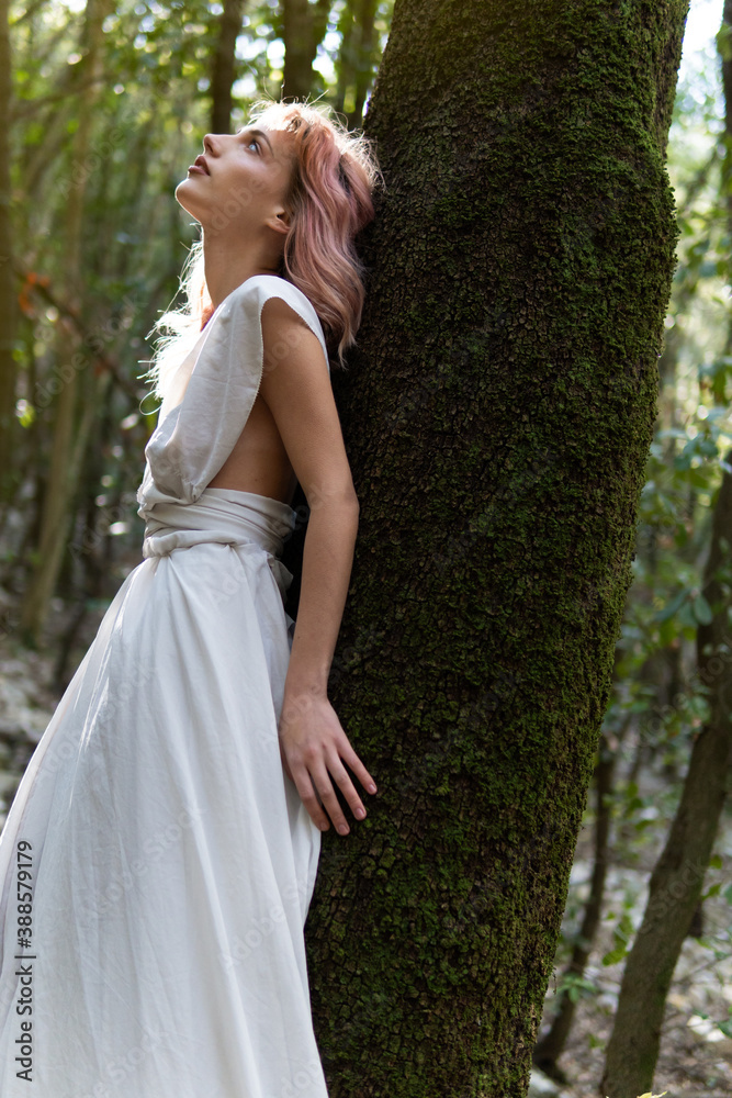 A woman in a white dress in the middle of the forest A woman in a white dress in the middle of the forest