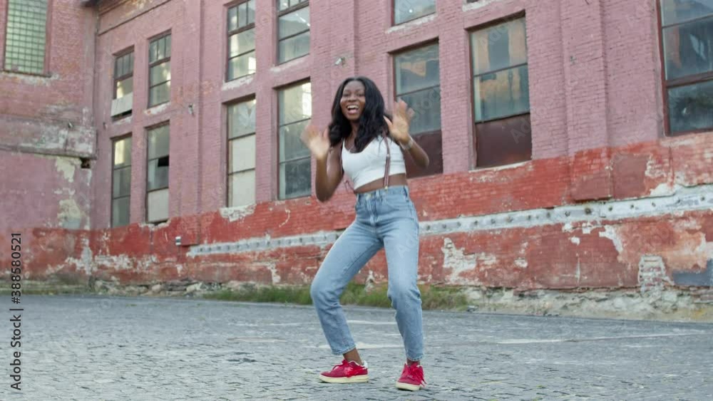 Girl Dancer Dancing On The Street. Black Young Girl Moves Rhythmically. She Has Long Black Hair. Girl Dancer Dancing On The Street. Black Young Girl Moves Rhythmically. She Has Long Black Hair.