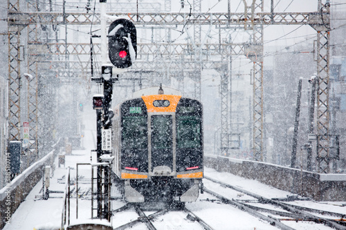 雪で徐行運転する電車 photo