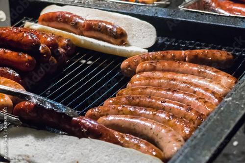 German sausages grilled in a steel container. Street food market