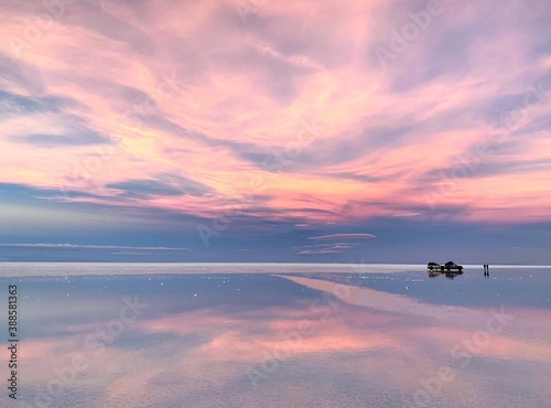 Fantasy sunset soft purple heaven clouds reflection in the tranquil sparkling lake water. Romantic pink twilight at desert night. Magic surreal zen landscape for love. Unique phenomenon nature.