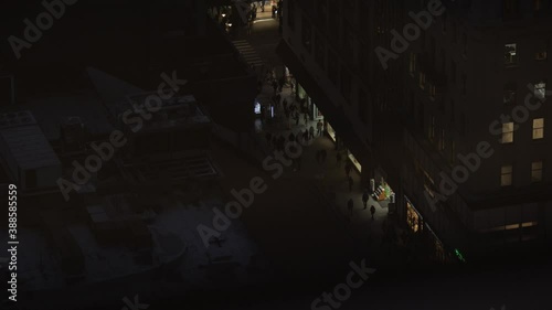 Busy New York City street from above after sunset. Pedestrians illuminated by storefronts. photo