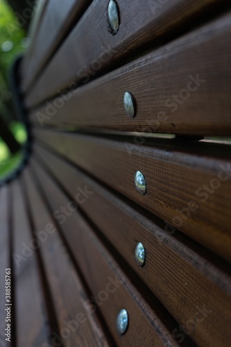 elements of the bench. Wooden slats with metal nails with round cap. Selective focus. bench in the city Park