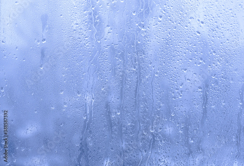  Drops of water on a window pane against the background of a cold winter day.