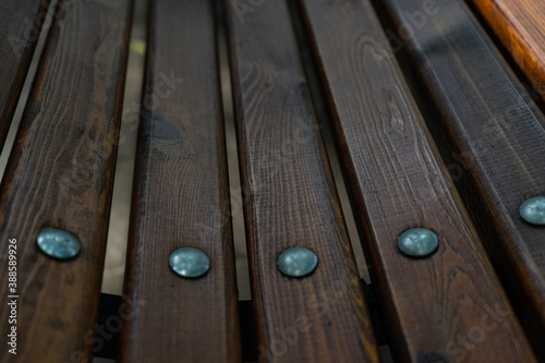 elements of the bench. Wooden slats with metal nails with round cap. Selective focus. bench in the city Park