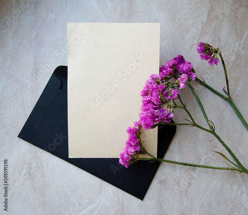 Greeting, post card, invitation card photo mock up on marble background with black envelope and decor.