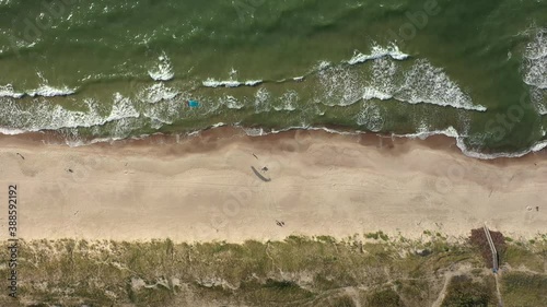 AERIAL: Top View Shot of Isolated Surfer with Wind Kite Standing on Beach with Rippling Waves