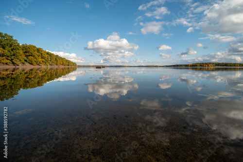 Lake level on an autumn afternoon. Reflecting cloudy sky.