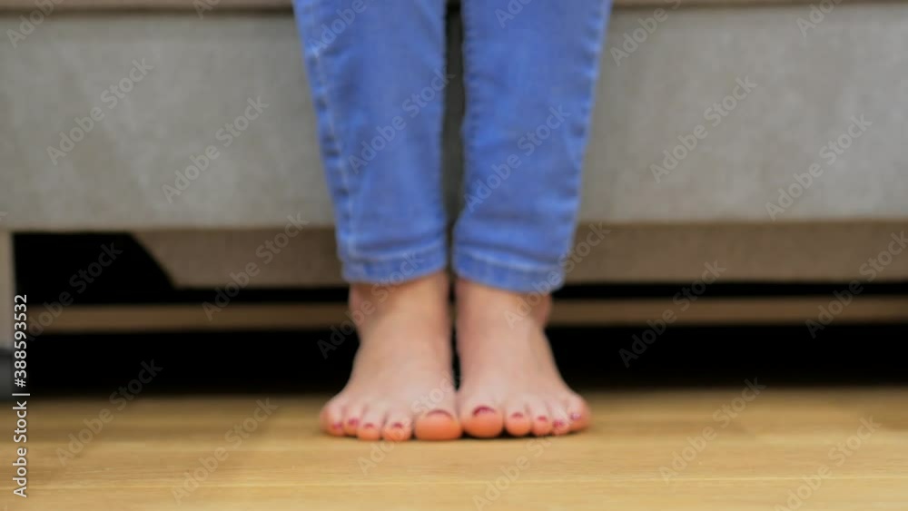 Barefoot woman picks up a wine glass from the wooden floor, drinks and then puts it back on Barefoot woman picks up a wine glass from the wooden floor, drinks and then puts it back on