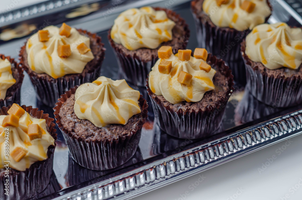 Salted caramel cupcakes on the  silver tray, tempting little chocolate cupcakes with a baileys flavour frosting and caramel drizzle