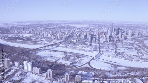 Aerial high above the city of Edmonton from the downtown south side of Whyte Avenue to river divide bewteen the 2 downtown districts on a clear winter day whereby snow covers the river & valley. AE1-3 photo