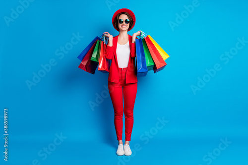 Full length body size view of nice fashionable cheerful lady wearing casual clothing carrying buyings isolated on bright blue color background
