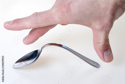 Photos Hand of man bending a spoon by power of telekinesis