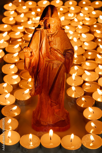 Obraz na plátně Statue of Jesus with many votive candles
