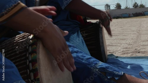 Mens in traditional Tuareg blue dresses, playing ethnic percussion in the Sahara desert in Morocco.