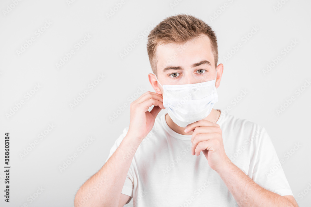 Man put hygienic mask to prevent infection, airborne respiratory illness such as flu, 2019-nCoV. indoor isolated on white background Man put hygienic mask to prevent infection, airborne respiratory illness such as flu, 2019-nCoV. indoor isolated on white background