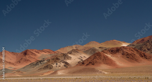 The Andes mountain range. Panorama view of the beautiful brown mountains high in the cordillera, under a deep blue sky.