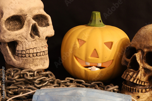 two skulls, a pumpkin and mask on chain