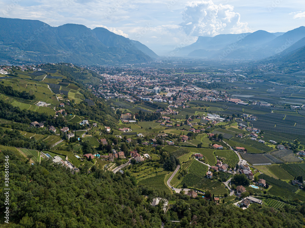 High angle view over the old South Tyrolean city of Merano / Meran and the surrounding valleys of Tyrol on a cloudy summer day.