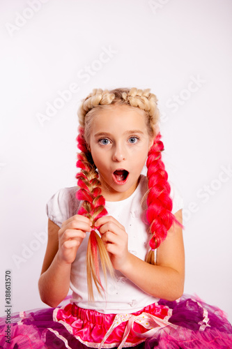 Fotografía surprised girl in bright colorful clothes braids pigtails