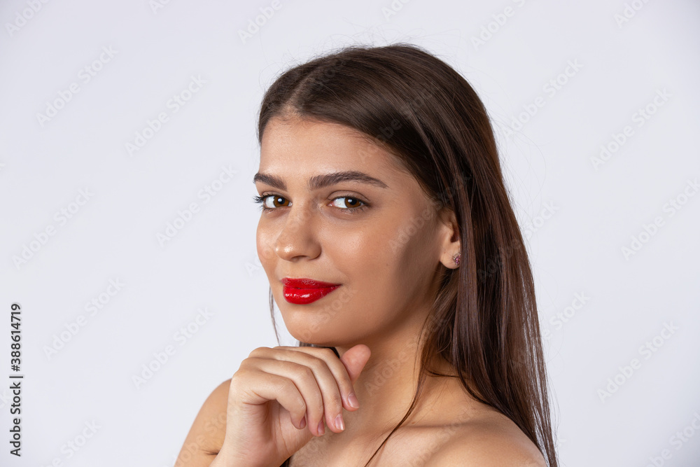 A beautiful brunette model with red lips looks at the camera. Beauty and makeup concept. Photo on white background A beautiful brunette model with red lips looks at the camera. Beauty and makeup concept. Photo on white background