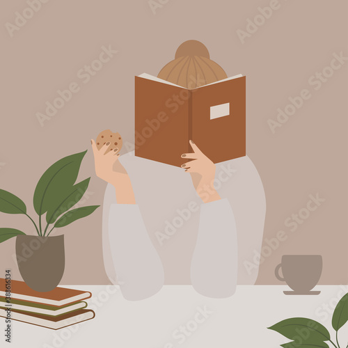 Girl reading a book and eating cookies while staying at home self-isolated