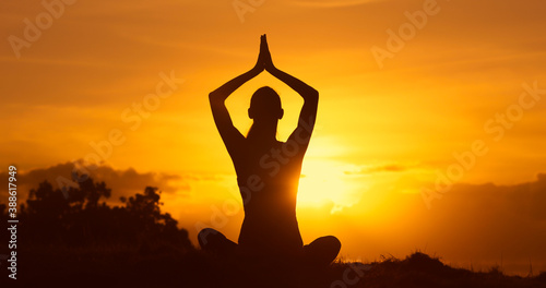 silhouette of a person meditating in the sunset