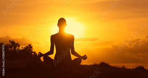 Fototapeta Naklejka Na Ścianę i Meble -  silhouette of a person meditating in the sunset