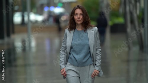 Wallpaper Mural confident woman is walking on city street, looking at camera and going forward, contemporary female city dweller Torontodigital.ca