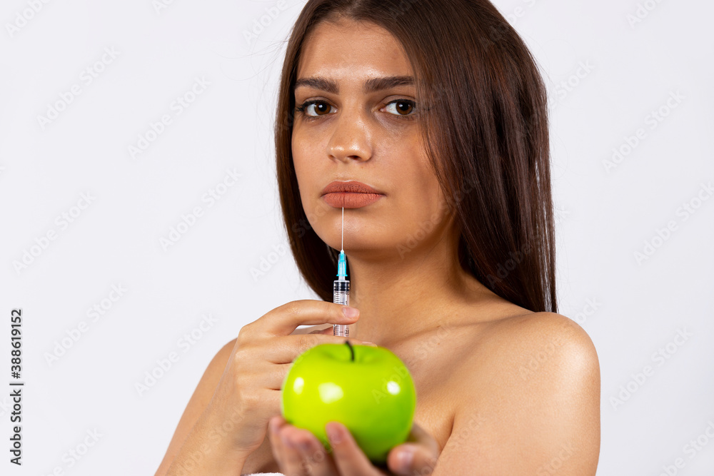 The good-looking brunette with long hair betrayed the importance of cosmological procedures rather than healthy eating. Photo on white background The good-looking brunette with long hair betrayed the importance of cosmological procedures rather than healthy eating. Photo on white background